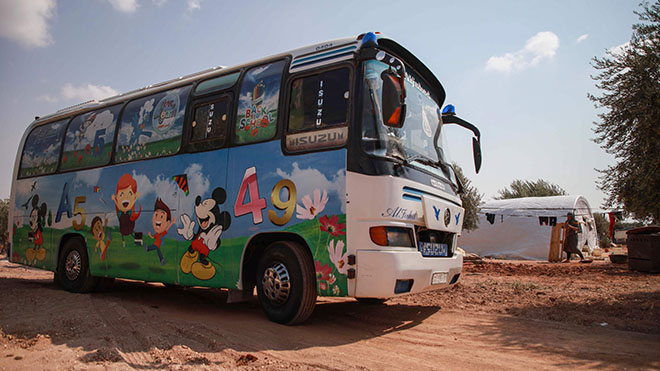 تصل حافلة تم تحويلها إلى فصل دراسي إلى مخيم بقرية هازانو في شمال غرب سوريا